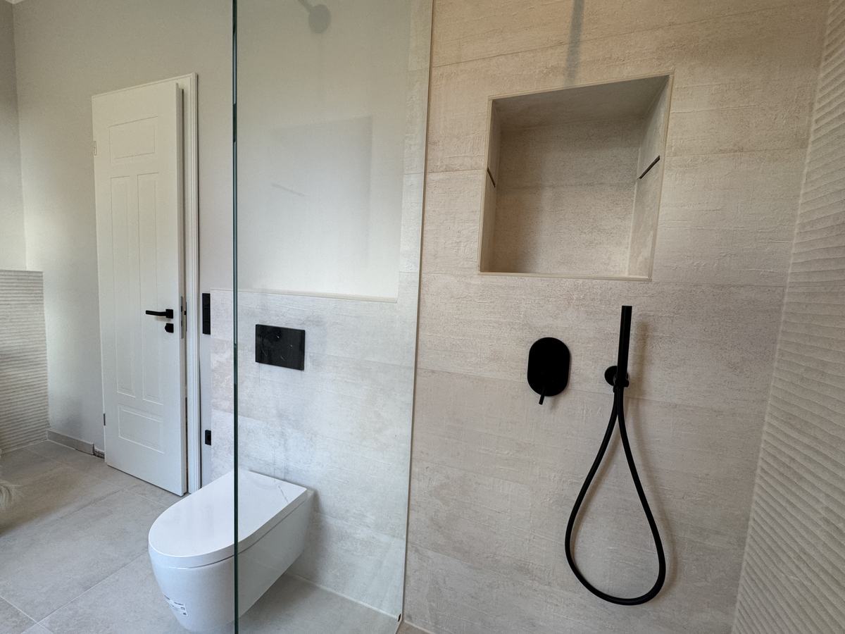 Bad mit bodengleicher Dusche und schwarz-matten Armaturen